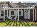 Inviting entrance showcasing a covered porch, seating, and charming architectural details for a warm welcome at 55 Lindsey St, Pittsboro, NC 27312