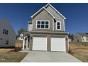 Charming two-story home featuring a brick and shake facade and a two-car garage at 75 Furley St., Homesite 115, Sanford, NC 27330