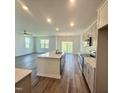 Bright, open kitchen with a large island and modern appliances and an adjoining living area at 75 Furley St., Homesite 115, Sanford, NC 27330