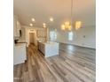 Open-concept kitchen with island seating and modern lighting, flowing into the living area at 75 Furley St., Homesite 115, Sanford, NC 27330