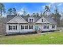 Charming exterior elevation of home featuring neutral siding, black shutters, dormers, and a vibrant blue front door at 90 Ferncrest Ct, Roxboro, NC 27574