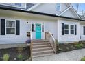 Welcoming front porch features stairs, flowers, and a vibrant blue door with sidelights and stone walkway at 90 Ferncrest Ct, Roxboro, NC 27574