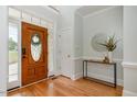 Bright foyer featuring a wooden front door with glass insert, light walls, and wood floors at 924 Elbridge Dr, Raleigh, NC 27603