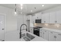 Well-lit kitchen with an island, stainless steel sink, and sleek black gas range at 1009 Shovelhead Dr # 5, Durham, NC 27703