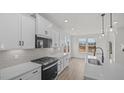 Bright kitchen features modern appliances, white cabinetry, and stylish pendant lighting at 1009 Shovelhead Dr # 5, Durham, NC 27703