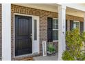 Inviting front entrance with a black door, brick facade, and a 'Welcome' sign at 110 White Burley Ct, Durham, NC 27703