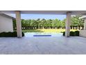 View from covered porch onto backyard featuring a pool, patio, privacy, and beautiful mature landscaping at 1216 Barcroft Pl, Raleigh, NC 27615