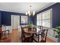 Elegant dining room featuring navy walls, white trim, hardwood floors, and refined traditional furnishings at 1417 Hathaway Rd, Raleigh, NC 27608