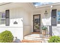 Inviting front porch with stylish address plaque, decorative lighting, and a freshly painted white brick facade at 1417 Hathaway Rd, Raleigh, NC 27608