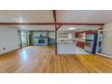 Spacious open-concept with hardwood floors, stone fireplace, a kitchen with white countertops and cherry cabinetry at 1481 Country Club Rd, Roxboro, NC 27574