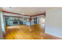 Open-concept living room featuring a stone fireplace, hardwood floors, and exposed beams, perfect for gatherings at 1481 Country Club Rd, Roxboro, NC 27574