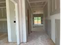 Unfinished hallway with exposed beams and light coming from the sliding glass doors in the distance at 15 Atherton Circle, Angier, NC 27501