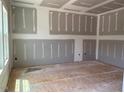 An unfinished room with drywall and exposed floor awaiting customization with natural light from a window at 15 Atherton Circle, Angier, NC 27501