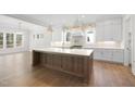 Bright kitchen features an island with seating, stainless steel appliances, and white cabinetry at 1520 Lake Adventure Ct, Raleigh, NC 27613