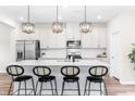Modern kitchen with stainless steel appliances, pendant lighting, and breakfast bar seating at 1613 Clayfire Dr, Cary, NC 27519