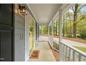 Covered front porch with concrete flooring, white railings, and a yellow front door with a 