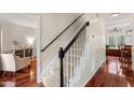Carpeted staircase with white risers and black handrail, with hardwood floors and living room views at 2032 Stoneglen Ln, Raleigh, NC 27603