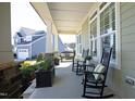 Inviting front porch with comfortable seating, stone accents, and views of the neighborhood at 208 Evanview Ct, Apex, NC 27523