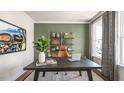 A modern office showcases a dark wooden desk, a leather chair, and stylish decorative elements on an olive accent wall at 213 Umstead St, Sanford, NC 27330