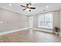Bright living room featuring wood-look floors, a ceiling fan, and natural light from a large window at 217 Waterford Lake Dr, Cary, NC 27519