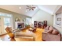 Bright living room with vaulted ceilings, fireplace, skylight, and hardwood flooring at 2440 Helena Moriah Rd, Timberlake, NC 27583