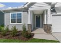 Close-up of the welcoming front porch featuring stone accents and a modern-style front door at 280 Providence Creek Dr, Fuquay Varina, NC 27526