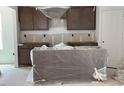 Kitchen with gray cabinets and an island covered in plastic sheeting at 39 Atherton Circle, Angier, NC 27501