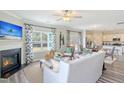 Open-concept living room with fireplace seamlessly connected to dining area and a modern kitchen at 39 Atherton Circle, Angier, NC 27501
