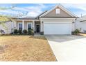 Charming home showcasing a well-maintained lawn, manicured shrubs and an attached two-car garage at 4102 Catfish Way, Durham, NC 27703