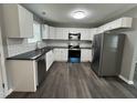 Modern kitchen with stainless steel appliances, white cabinets, and sleek black countertops at 427 Elm Ct, Burlington, NC 27215
