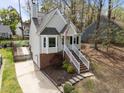 View of the home's charming exterior, brick foundation, front stairs, driveway, and surrounding yard at 4724 Worchester Pl, Raleigh, NC 27604