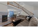 Inviting living room featuring a brick fireplace, hardwood floors, and a staircase with iron railings at 4724 Worchester Pl, Raleigh, NC 27604