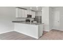Modern kitchen with white cabinets, granite countertops, and stainless steel appliances at 54 Crow Field St, Roxboro, NC 27574