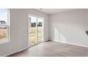Bright living room with wood-look floors and sliding glass doors to the backyard at 54 Crow Field St, Roxboro, NC 27574