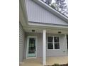 Close-up of the front porch features a light blue door, white pillars, and nice window at 5710 Russell Rd, Durham, NC 27712