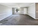 Spacious living room with a large window, neutral walls, and plush carpeting at 5908 O C Hester Rd, Holly Springs, NC 27540
