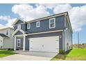 Two-story home featuring a two-car garage and blue siding, with a well maintained lawn at 601 White Birch Ln, Angier, NC 27501