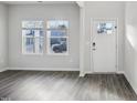 Living room with white walls, wood-look floors, and natural light from two windows at 601 White Birch Ln, Angier, NC 27501