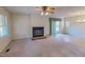 Spacious living room featuring a fireplace, ceiling fan, and large window for natural light at 604 Orange Factory Road, Bahama, NC 27503
