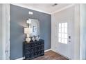 Elegant entryway featuring wood floor, stylish chest, designer mirror, and a brightly lit front door at 61 Atherton Circle, Angier, NC 27501