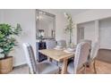 Bright dining room with a wooden table, upholstered chairs, large mirror, and floral arrangement on a stylish sideboard at 62 Atherton Circle, Angier, NC 27501