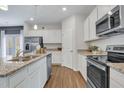 Modern kitchen with white cabinets, stainless steel appliances, granite countertops, and wood-look flooring for a stylish look at 62 Atherton Circle, Angier, NC 27501