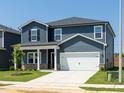 Lovely two-story home showcasing blue siding, a welcoming porch, and a two-car garage at 621 White Birch Ln, Angier, NC 27501