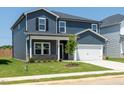 Charming two-story home showcasing blue siding, a welcoming porch, and a well-manicured lawn at 621 White Birch Ln, Angier, NC 27501