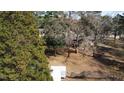 Large backyard with mature trees surrounding the home and a utility shed at 640 Sunnybrook Rd, Raleigh, NC 27610