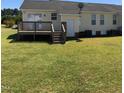A cozy wooden deck extends from the home to a lush, green backyard, perfect for relaxing at 70 Ariel St, Lillington, NC 27546
