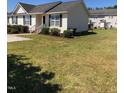 Charming home with black shutters and manicured lawn, offering a serene suburban living experience at 70 Ariel St, Lillington, NC 27546