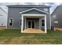View of the home's rear exterior with a covered patio and well-maintained lawn at 766 Old Station Pointe, Angier, NC 27501