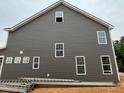 Side view of the new construction home featuring gray siding and white trim, accentuating its modern aesthetic at 766 Old Station Pointe, Angier, NC 27501