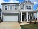 Inviting two-story home boasts a two-car garage and classic architectural details at 766 Old Station Pointe, Angier, NC 27501